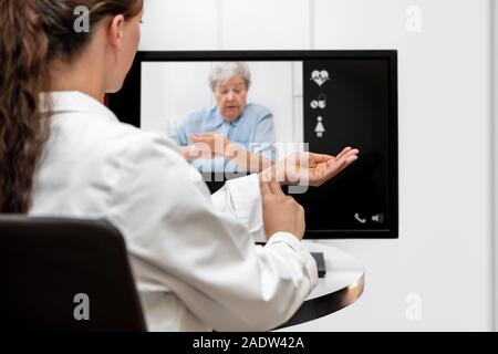 Arzt und der älteren Frau, die mit dem Impuls zusammen, Telemedizin und Bildtelefonie für medizinischen Versorgung Stockfoto