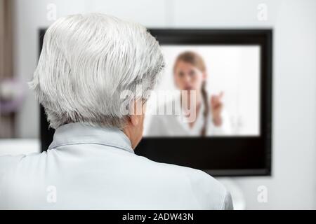 In-home Care für einen älteren Patienten mit Telemedizin oder Telehealth, virtuelle Live Chat auf dem Monitor Stockfoto