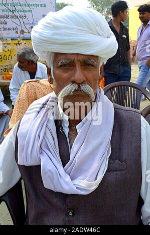 Ältere Indische Männer mit Cowboy Schnurrbart trägt Rajasthani traditionellen Turban und posiert für die Kamera. Foto/Sumit Saraswat Stockfoto