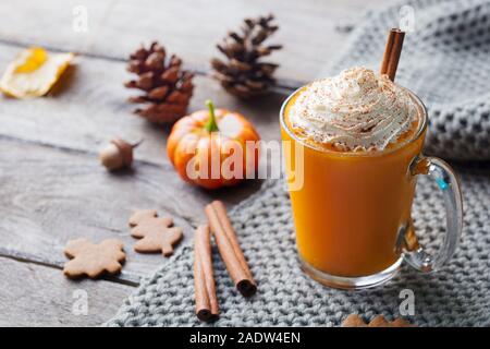 Kürbis Latte mit Gewürzen. Versoffenes Cocktail mit Schlagsahne. Holz- Hintergrund. Platz kopieren Stockfoto