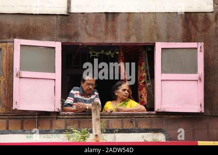 PUNE, MAHARASHTRA, Indien, September 2019, alte Paar sehen, Blick auf die Straße, die von ihrer Heimat Fenster Stockfoto