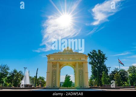 Duschanbe Abu Abdullah Rudaki Park malerische Ansicht triumphbogen Eingangstor mit Blumen an einem trüben Regentag Stockfoto