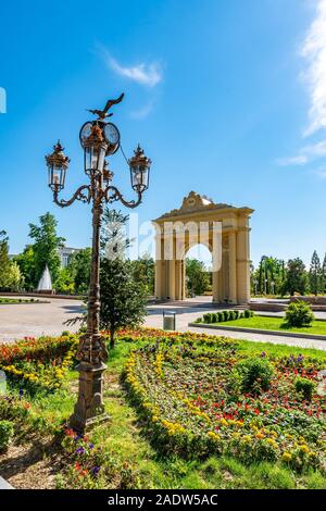 Duschanbe Abu Abdullah Rudaki Park malerische Ansicht triumphbogen Eingangstor mit Blumen und Straßenbeleuchtung an einem bewölkten Tag Stockfoto