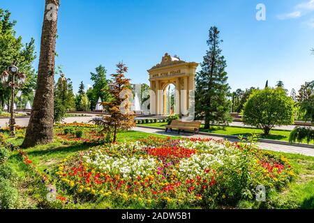 Duschanbe Abu Abdullah Rudaki Park malerische Ansicht triumphbogen Eingangstor mit Blumen an einem trüben Regentag Stockfoto