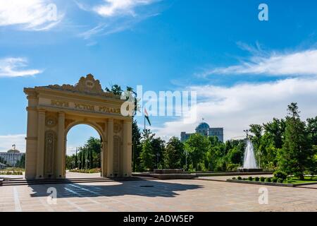 Duschanbe Abu Abdullah Rudaki Park malerische Ansicht triumphbogen Eingangstor mit Blumen an einem trüben Regentag Stockfoto