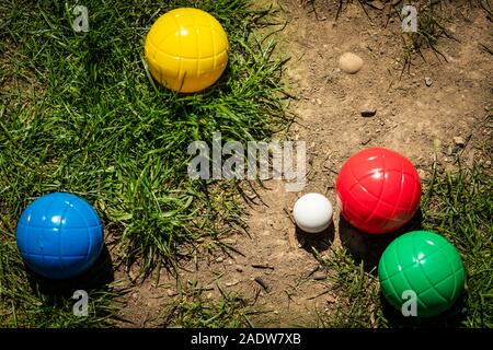 Viele bunte Kunststoff Boule oder Boccia Kugeln liegen auf der grünen Wiese im Sommer Stockfoto