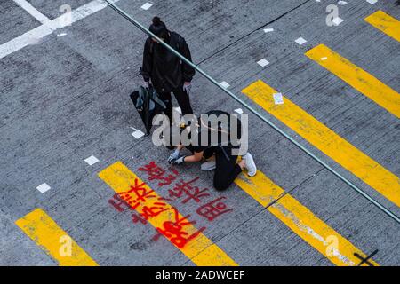 HongKong - November, 2019: Demonstrant schreibt Graffiti auf fußgängerüberweg während der 2019 HongKong Proteste, Demonstrationen in Hongkong gestartet als Anti-Extradition Gesetz änderung Rechnung (Anti-Elab) Bewegung. Stockfoto