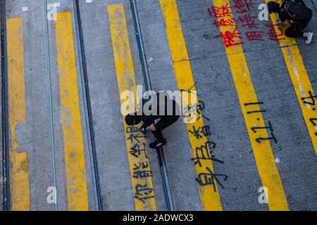 HongKong - November, 2019: Demonstrant schreibt Graffiti auf fußgängerüberweg während der 2019 HongKong Proteste, Demonstrationen in Hongkong gestartet als Anti-Extradition Gesetz änderung Rechnung (Anti-Elab) Bewegung. Stockfoto