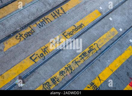 HongKong - November, 2019: Graffiti Lesung" Stand mit HK! Kampf für die Freiheit!" auf fußgängerüberweg während der 2019 HongKong Proteste Stockfoto