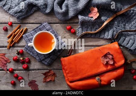 Tasse Tee und Frau Beutel mit strickschal. Holz- Hintergrund. Ansicht von oben. Stockfoto