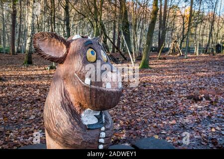 Eine aus Holz geschnitzte Statue eines Babys Gruffalo in einem herbstlichen Thorndon Park North in Brentwood, Essex, an. Stockfoto