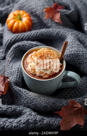 Kürbis Latte mit Gewürzen. Versoffenes Cocktail mit Schlagsahne. Grau gestrickt Hintergrund. Platz kopieren Stockfoto