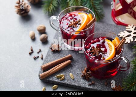 Glühwein Rotwein mit Gewürzen. Weihnachtsdekoration. Grauen Stein Hintergrund. Platz kopieren Stockfoto