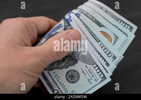 Geld in die Hand. Mann hält in seiner Hand ein Wad des Amerikanischen Dollar. Stockfoto