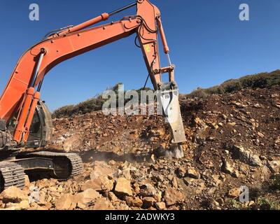 Hydrohammer ist crushing Felsen während der straßenbauarbeiten auf der felsigen Böden. Schwere Maschinen zur Erdbewegung, Graben, Aushub. Stockfoto