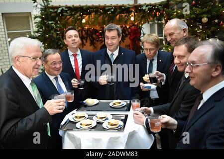 05 Dezember 2019, Berlin: Winfried Kretschmann (Bündnis 90/Die Grünen, l-r), Ministerpräsident von Baden-Württemberg, Armin Laschet (CDU), Ministerpräsident von Nordrhein-Westfalen, Tobias Hans (CDU), Ministerpräsident des Saarlandes, Markus Söder (CSU), Ministerpräsident von Bayern, sind in Abstimmung mit der Nürnberger Rostbratwürstel und Glühwein, Daniel Günther (CDU), Ministerpräsident von Schleswig-Holstein, Dietmar Woidke (SPD), Ministerpräsident von Brandenburg, Michael Kretschmer (CDU), Ministerpräsident von Sachsen, und Reiner Haselhoff (CDU), Ministerpräsident des Landes Sachsen-Anhalt, an der Ministerpräsident die Conferen Stockfoto