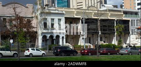 Fahrzeuge vor einer Reihe von Terrassenhäusern auf Drummond St Carlton Melbourne Australien geparkt. Stockfoto