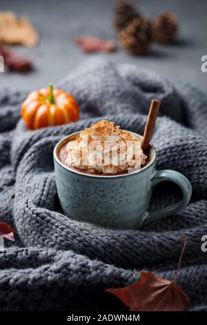 Kürbis Latte mit Gewürzen. Versoffenes Cocktail mit Schlagsahne. Grau gestrickt Hintergrund. Platz kopieren Stockfoto