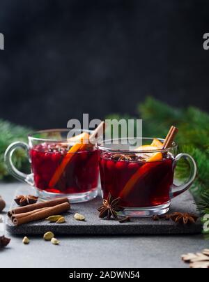 Glühwein Rotwein mit Gewürzen. Weihnachtsdekoration. Grauer Hintergrund. Platz kopieren Stockfoto