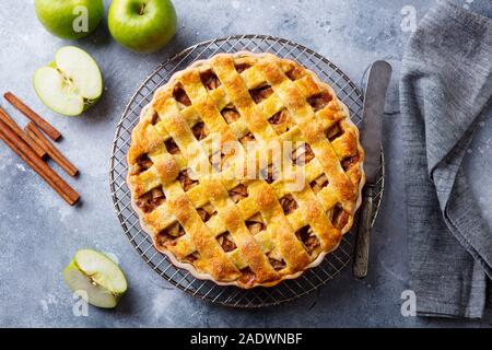 Apfelkuchen mit Karamell auf ein Gitter. Grauer Hintergrund. Ansicht von oben Stockfoto