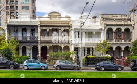 Drummond Street Autos vor einer Reihe von Reihenhäuser in Carlton Melbourne Victoria Australien geparkt. Stockfoto