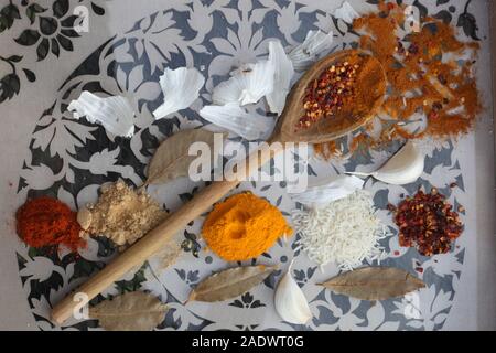 Spice Tabellen - Ansicht von oben, aus einer Vielzahl von Gewürzen, einschließlich Kurkuma Wurzel Pulver, Ingwer, Paprika, Chili Flocken bestreuen auf einem Löffel aus Holz. Stockfoto