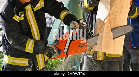 Feuerwehrmann arbeitet mit einer Kettensäge outdoor Stockfoto