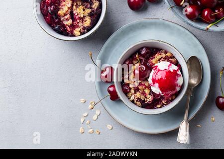 Cherry mit Eis in der Schüssel zerbröseln. Grauer Hintergrund. Kopieren Sie Platz. Ansicht von oben Stockfoto