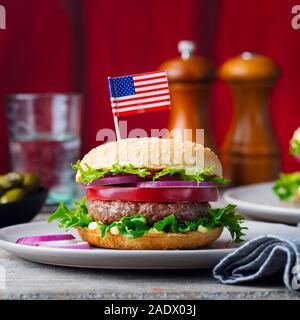 Burger auf einem Teller mit amerikanischer Flagge. Holz- Hintergrund. Nahaufnahme Stockfoto