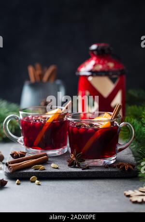 Glühwein Rotwein mit Gewürzen. Weihnachtsdekoration. Grauer Hintergrund. Platz kopieren Stockfoto
