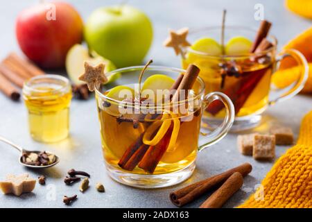 Apple Glühwein Apfelwein mit Gewürzen in Glas Schale. Grauer Hintergrund. Nahaufnahme Stockfoto