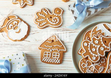 Flach Zusammensetzung mit Platte von Weihnachtsplätzchen, Geschenkboxen auf weißem Holz- Hintergrund. Ansicht von oben Stockfoto