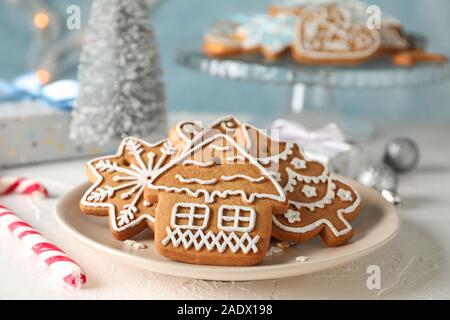 Mit Weihnachtsplätzchen Platte, Weihnachtsbäume, Spielwaren, Geschenk, Kästen auf weißer Tisch, vor blauem Hintergrund, Nahaufnahme Stockfoto