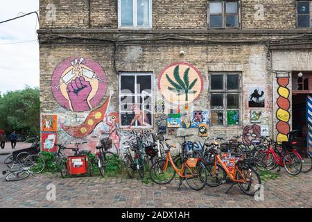 Christiania Freetown, Blick auf eine bebilderte Bau und abgestellte Fahrräder im alternativen Bereich Freetown von Christiania, Kopenhagen, Dänemark. Stockfoto