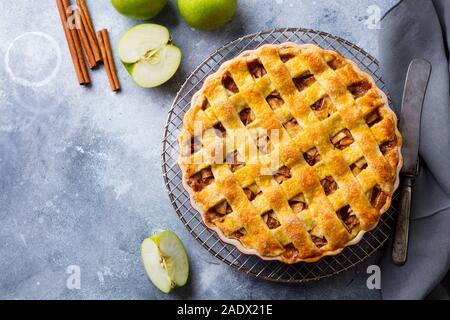 Apfelkuchen mit Karamellsauce auf einem Gitter. Grauer Hintergrund. Kopieren Sie Platz. Ansicht von oben Stockfoto