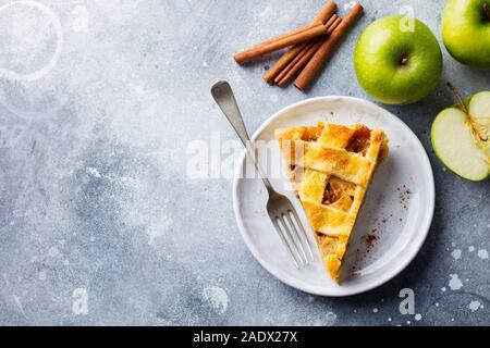 Apfelkuchen auf einem weißen Teller. Grauer Hintergrund. Kopieren Sie Platz. Ansicht von oben Stockfoto