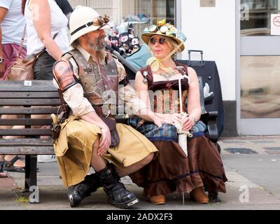 Eine steampunk Paar auf einer Bank sitzen im Sommer Rochester Dickens Festival 2019. Stockfoto