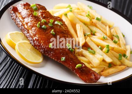 Hauptgericht gebratene rockfish mit Pommes frites in der Nähe serviert in einem Teller auf dem Tisch. Horizontale Stockfoto