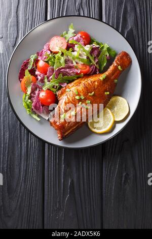 Lecker ganze gebratene Sebastes Fisch mit frischem Gemüse Salat in der Nähe serviert in einem Teller auf dem Tisch. Senkrechte Draufsicht von oben Stockfoto