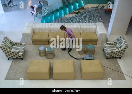 Hohe Betrachtungswinkel und einer Frau Absaugen der Teppich im Wohnzimmer Stockfoto