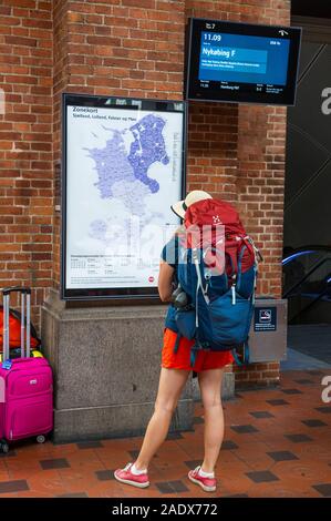 Ein Pendler mit einem Rucksack am Bahnhof Reiseziele am Hauptbahnhof von Kopenhagen, Kopenhagen, Dänemark suchen Stockfoto