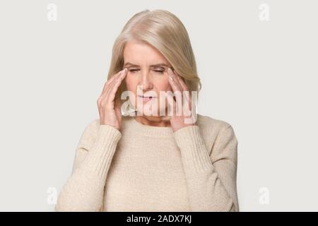 Porträt der alten Frau, die schreckliche Kopfschmerzen mit geschlossenen Augen Stockfoto