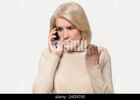 Headshot genervt alte Frau in Argument sprechen über Smartphone Stockfoto