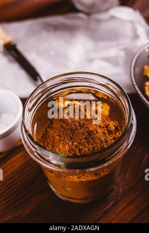 Kakao Pulver im Glas Zutaten für selbstgemachte Backen auf braune Holztisch, close-up. Stockfoto