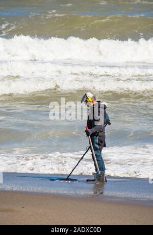 Mann im Anzug am Strand mit Metalldetektor, Spanien suchen. Stockfoto