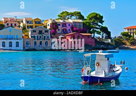 Einen schönen Blick über den malerischen Hafen an das hübsche Fischerdorf von Assos. Bunte Häuser, Fischerboot und kristallklarem Wasser. Stockfoto