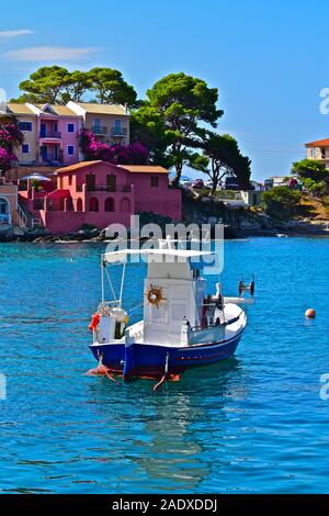 Einen schönen Blick über den malerischen Hafen an das hübsche Fischerdorf von Assos. Bunte Häuser, Fischerboot und kristallklarem Wasser. Stockfoto