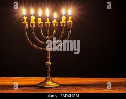 Menorah mit 7 brennenden Kerzen. Stockfoto