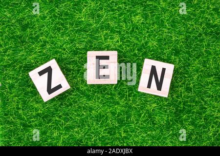 Wort Zen in Holz Buchstaben auf Gras gelegt geschrieben. Konzept von Wellness Hintergrund Stockfoto