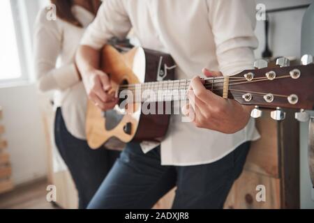 Elegante Menschen. Nähe zu sehen. Gitarrist spielen Love Song für seine Freundin in der Küche Stockfoto